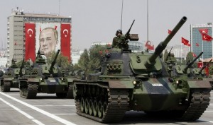 Turkish army tanks roll past a portrait of Mustafa Kemal Ataturk during a military parade in Ankara